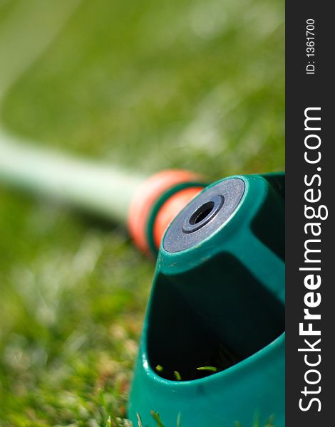 Shallow depth of field hosepipe sprinkler grass. Shallow depth of field hosepipe sprinkler grass