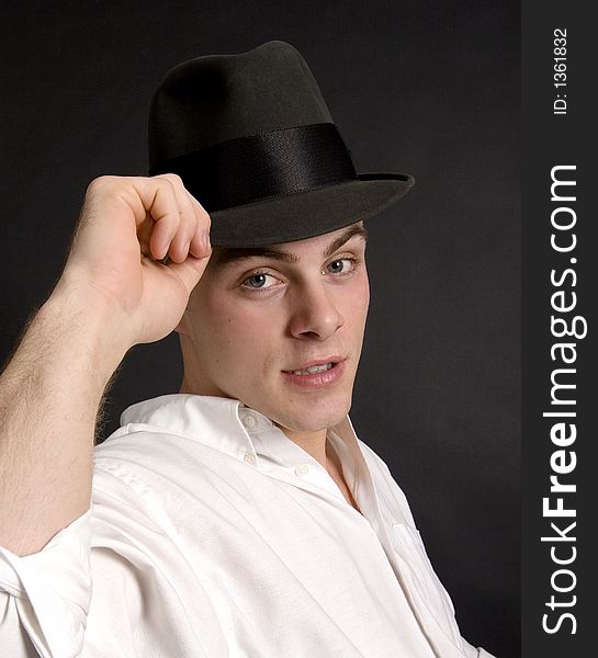 Handsome young man tipping his felt hat. Handsome young man tipping his felt hat