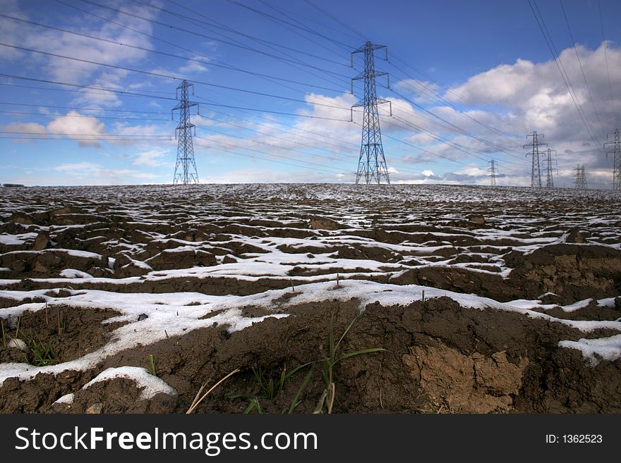 Pylons in ploughed snowy field. Pylons in ploughed snowy field