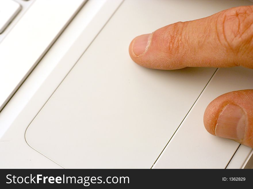 Closeup showing fingers using laptop touchpad