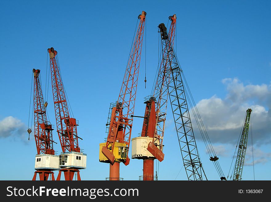 Industrial cranes in port against sky