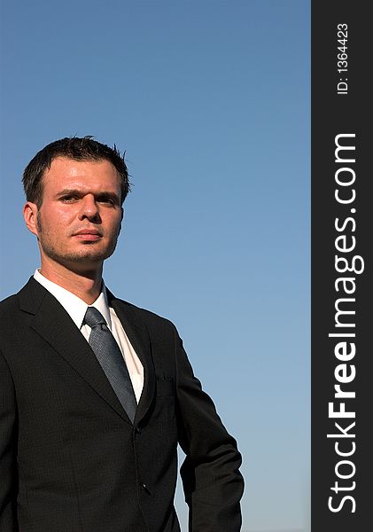 Young businessman with a blue sky behind him. Young businessman with a blue sky behind him.
