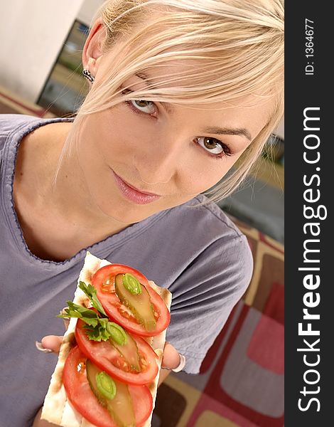Blond, young girl, woman eating a tomato sandwich