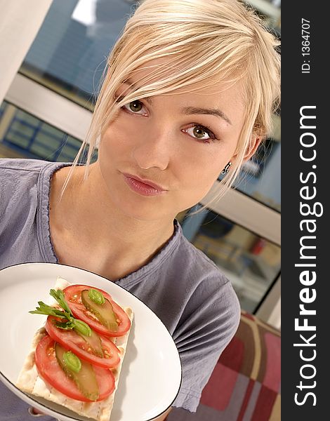 Blond, young girl, woman eating a tomato sandwich