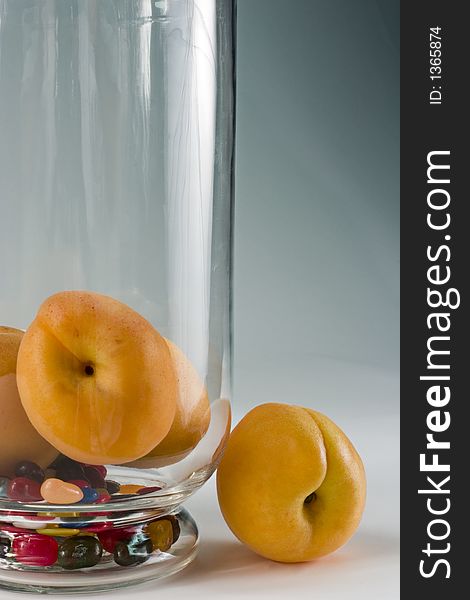 Still life with apricots and jelly beans in a crystal vase.
