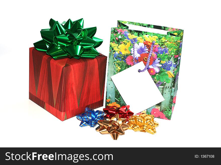 Christmas boxed gift with a ribbon and a gift bag with bow ribbons isolated on white with a gift card to put your message on. Christmas boxed gift with a ribbon and a gift bag with bow ribbons isolated on white with a gift card to put your message on