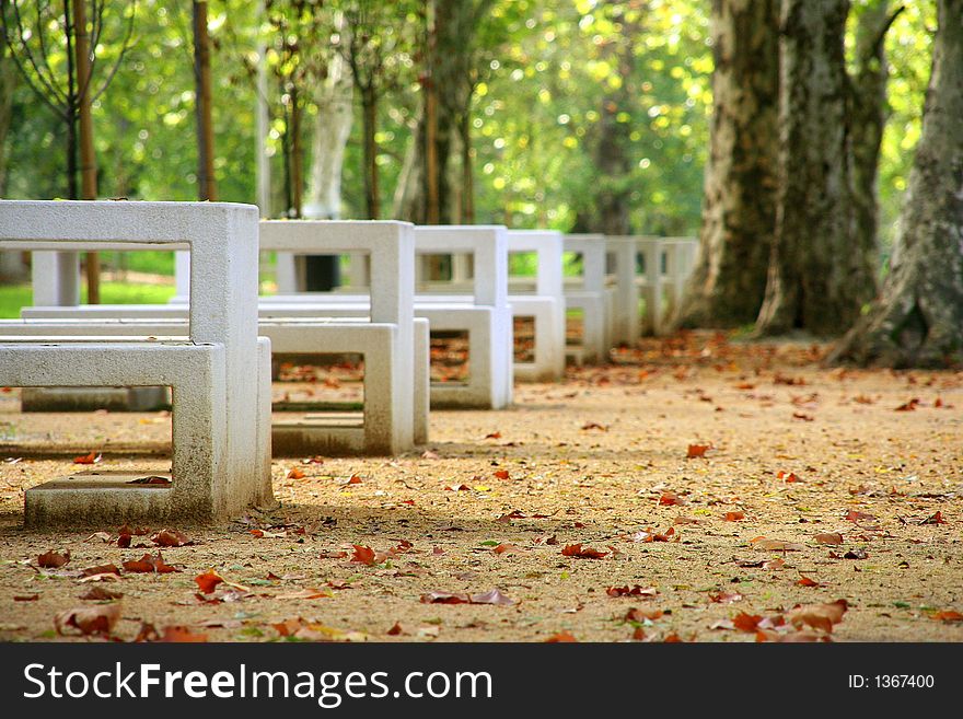 A row of white benches on a park. A row of white benches on a park.