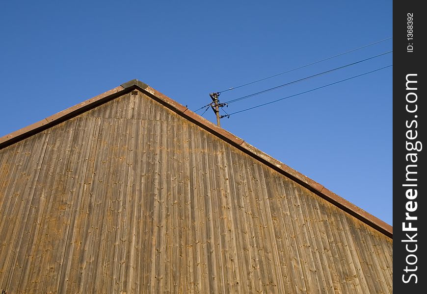 Wooden roof facade of a german barn with electric wires. Wooden roof facade of a german barn with electric wires