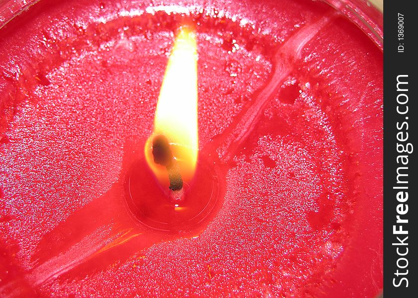 Closeup of a lit red candle. Closeup of a lit red candle