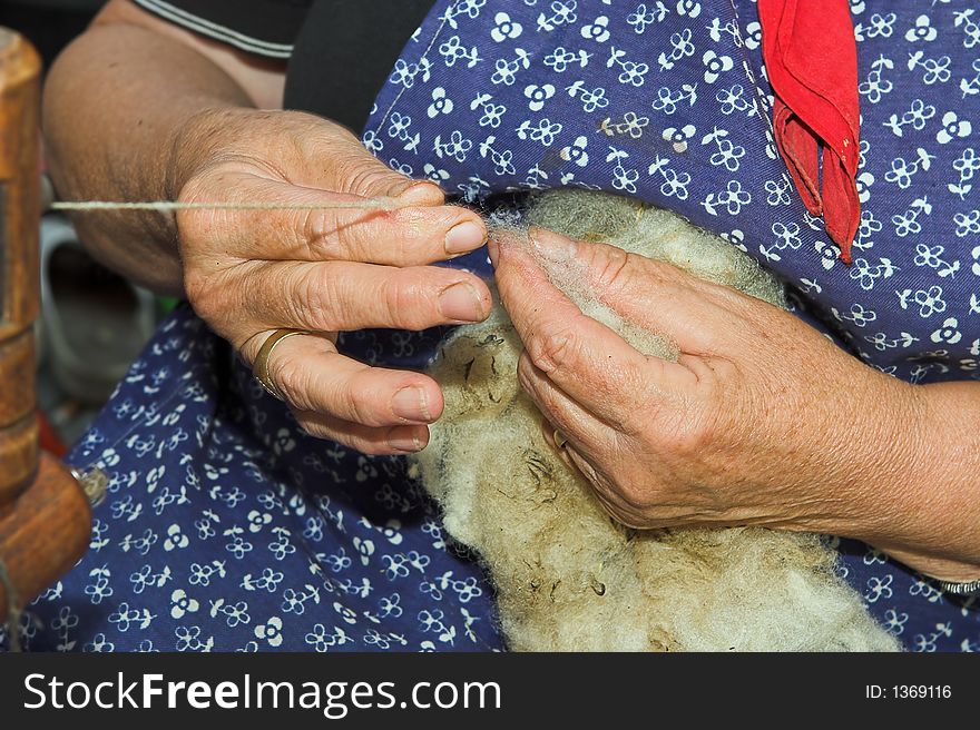 Hands of an old craftswoman, spinning wool. Hands of an old craftswoman, spinning wool