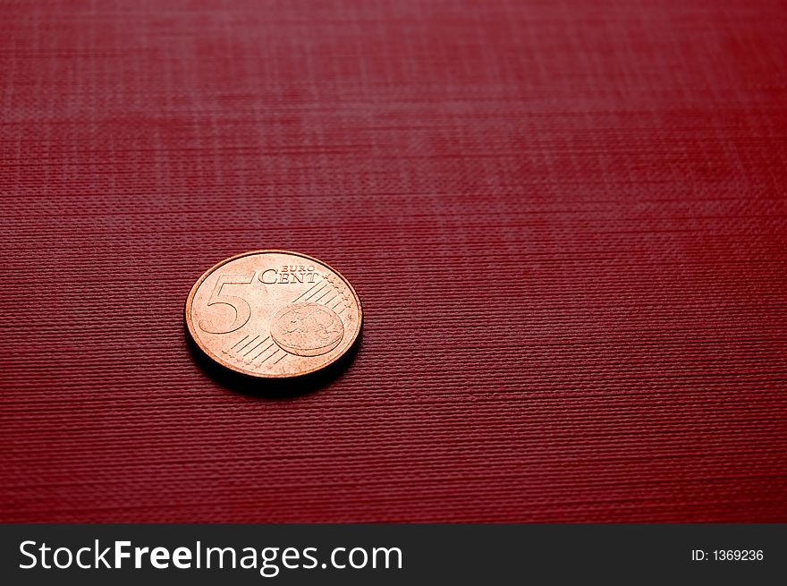 Coin (5 euro cent) on red surface. Coin (5 euro cent) on red surface