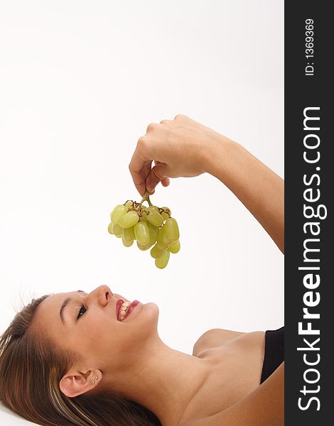 A girl smiles, after her workout, at some fresh green grapes that she knows she's going to enjoy. A girl smiles, after her workout, at some fresh green grapes that she knows she's going to enjoy.