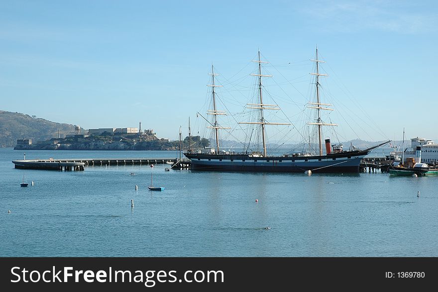 Alcatraz Island and sailing ship in the foreground with calm sea. Alcatraz Island and sailing ship in the foreground with calm sea