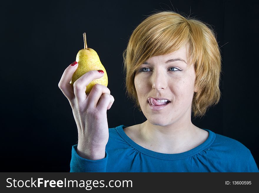 Cute young blond girl holding a pear. Cute young blond girl holding a pear