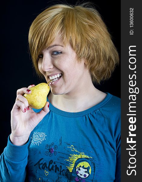 Cute young blond girl holding a pear. Cute young blond girl holding a pear