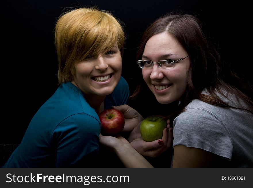 Two teen girls holding apples. Two teen girls holding apples