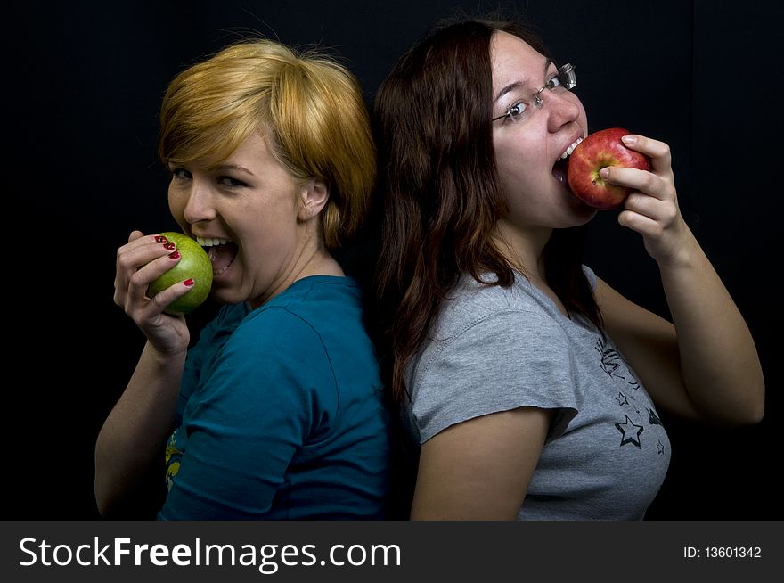 Two girls eating fresh fruits