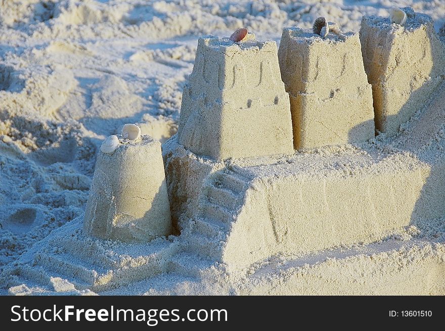 Towers of sandcastle with shell decorations on the beach. Towers of sandcastle with shell decorations on the beach.