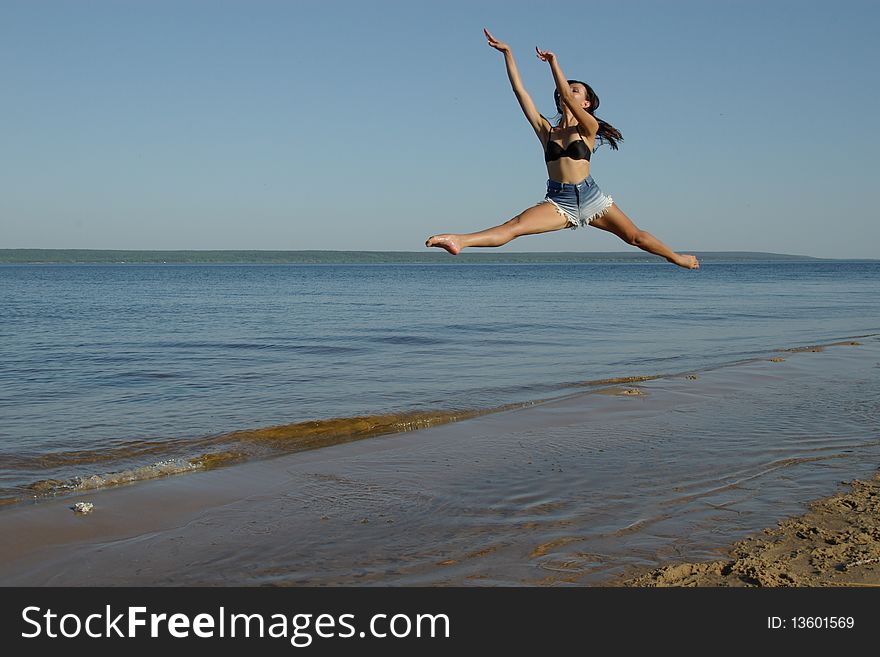 Girl jumping on the river bank. Girl jumping on the river bank.