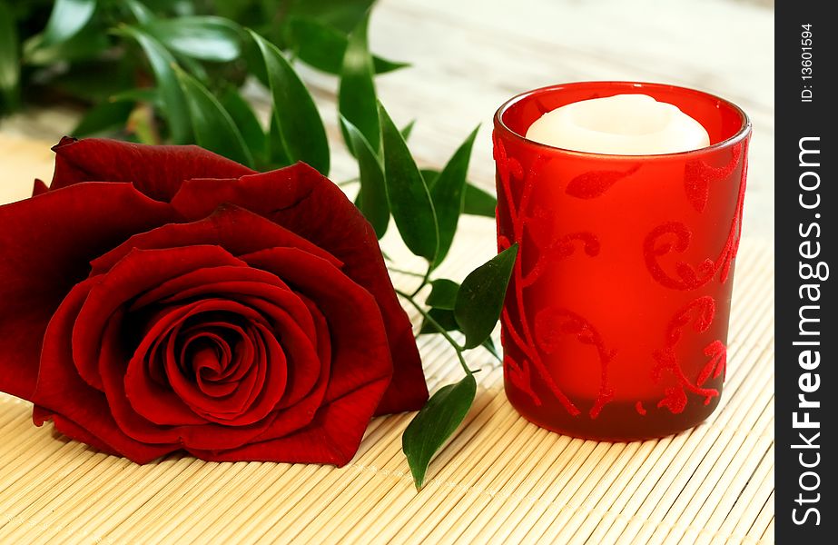 beautiful red rose and red candle on wooden