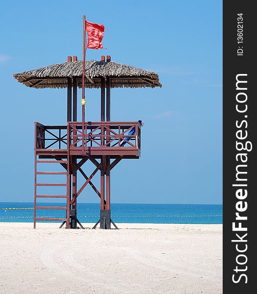 Red flag on a beach against blue sky