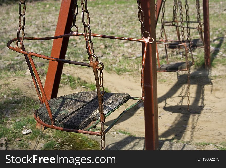 Old swing set at a lonely playground. Old swing set at a lonely playground.