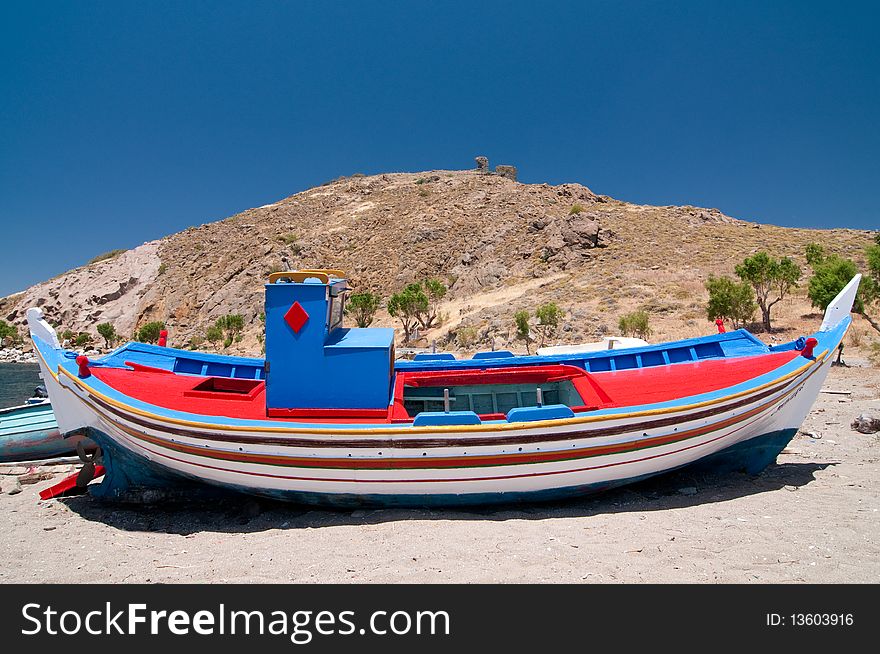 Small colourful fishing boat being repaired