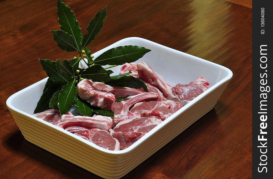 Lamb chops with bay leaves in a baking dish