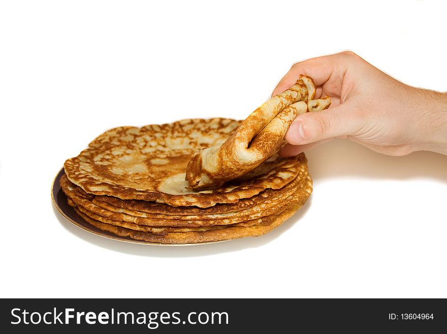 Pile of russain pancakes on the blue plate and hand, which take one pancakes. Pile of russain pancakes on the blue plate and hand, which take one pancakes