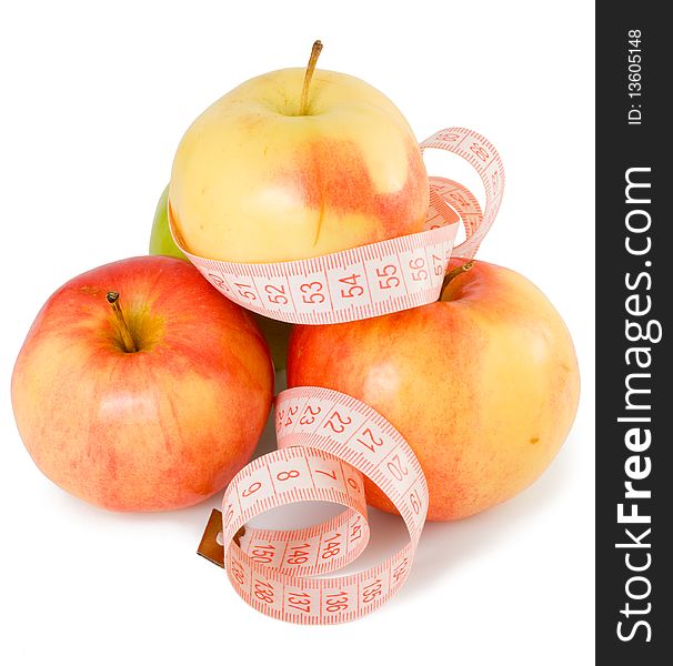 Pink measuring tape and some apples on a white background