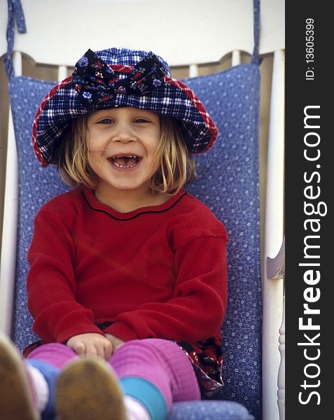 Cute little girl sitting in a white chair. Cute little girl sitting in a white chair