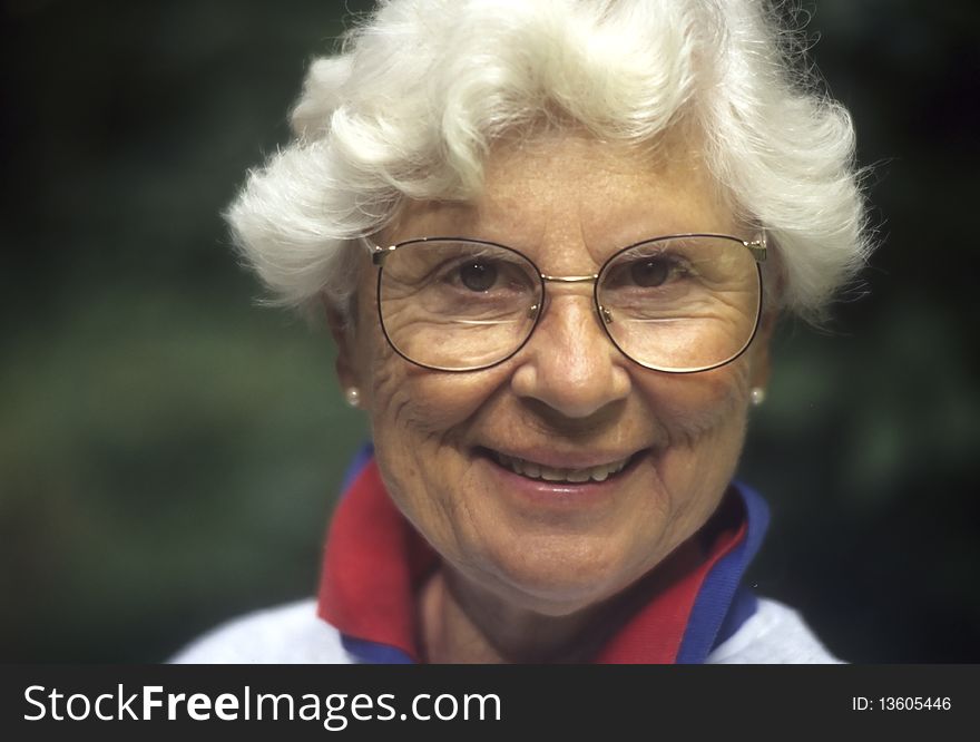 Senior woman with white hair and glasses