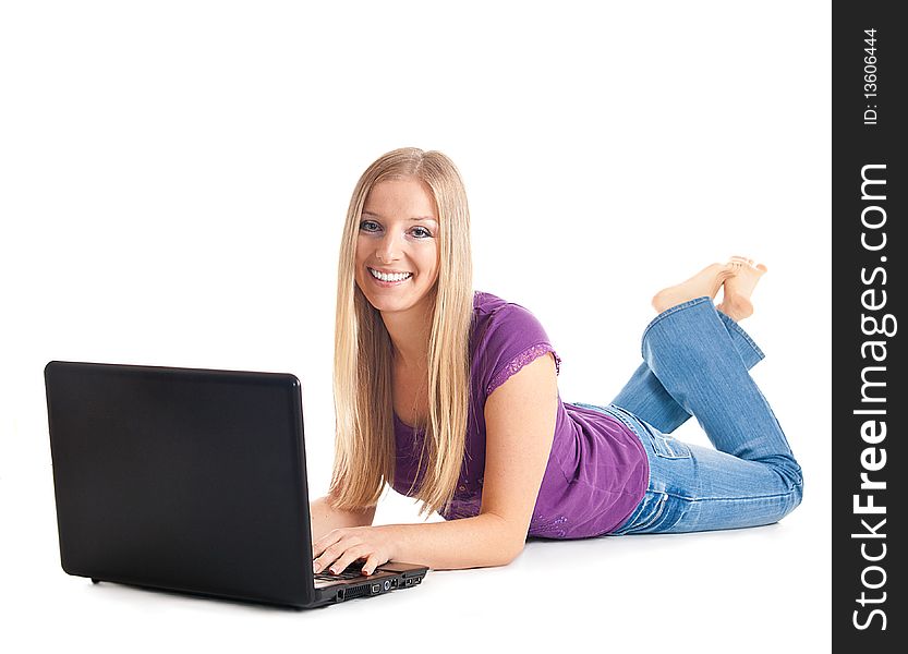 White girl lying on the floor smiling and typing on laptop. White girl lying on the floor smiling and typing on laptop