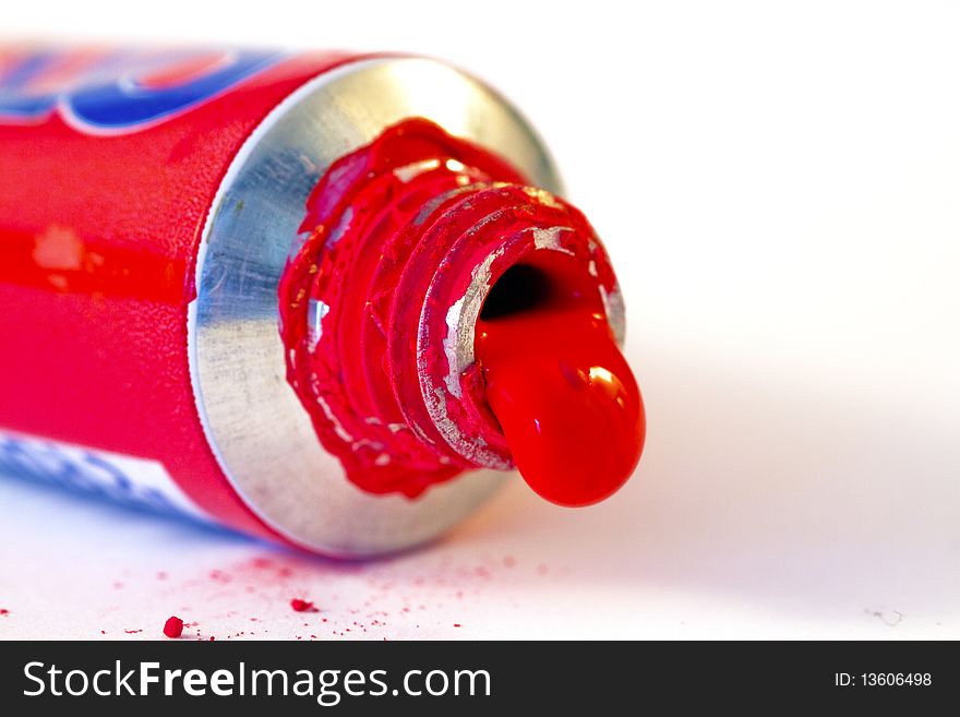 Tube of red paint on a white background