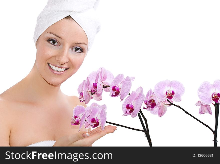 Woman with towel on head, after bath holding violet orchid flowers on hand. Woman with towel on head, after bath holding violet orchid flowers on hand