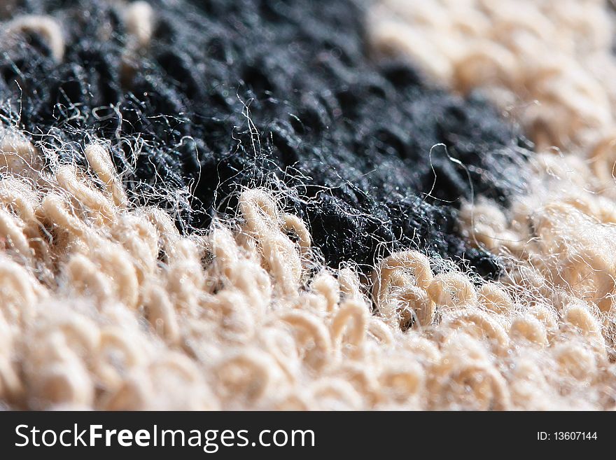 The close up of a thread from which weaves a carpet.