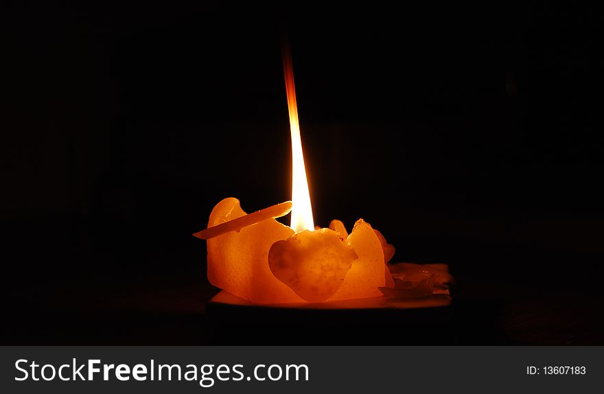 A sole lit candle to symbolise a light of hope in times of despair (darkness). A sole lit candle to symbolise a light of hope in times of despair (darkness)