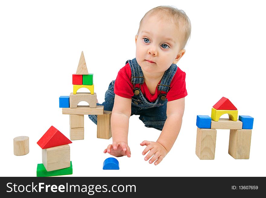 Little cute boy builds houses out of colored blocks. Little cute boy builds houses out of colored blocks