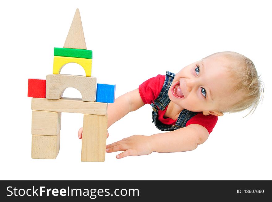 Little cute boy builds houses out of colored blocks. Little cute boy builds houses out of colored blocks