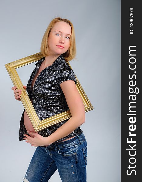 Young happy pregnant blond girl with the frame