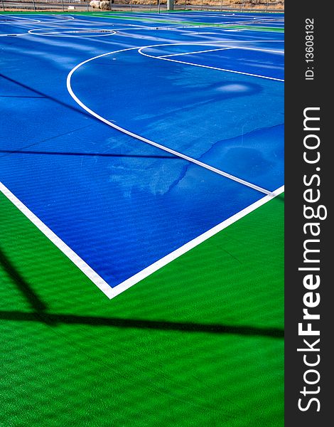 A blue and green basketball court after a good rain. A blue and green basketball court after a good rain.