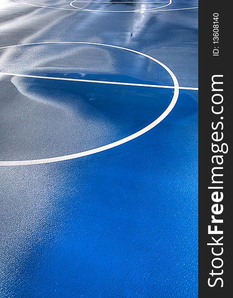 A blue and green basketball court after a good rain. A blue and green basketball court after a good rain.