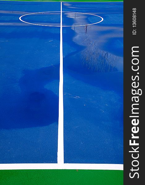 A blue and green basketball court after a good rain. A blue and green basketball court after a good rain.