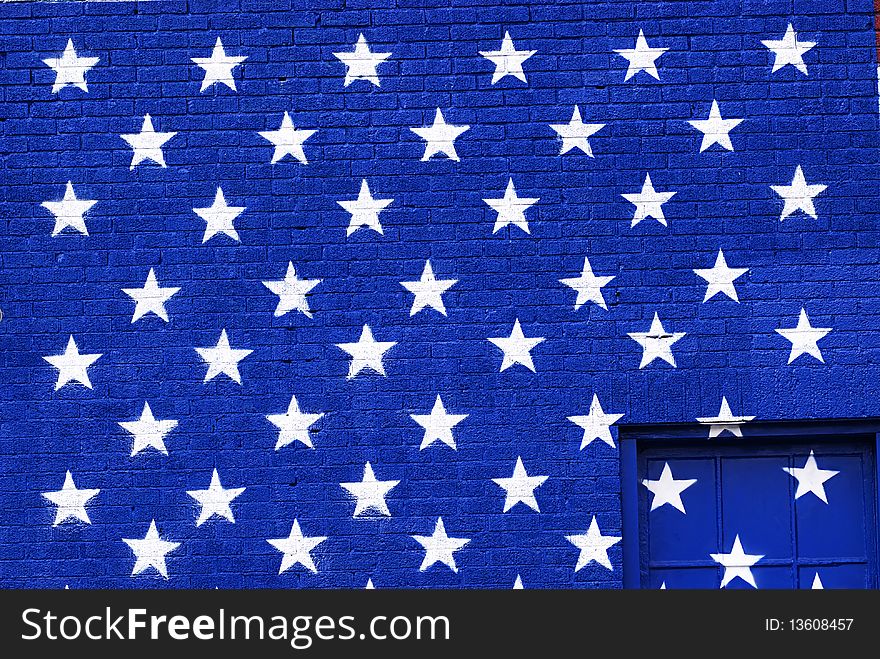 Graffiti styled grunge painted american flag stars on a blue brick background. Graffiti styled grunge painted american flag stars on a blue brick background