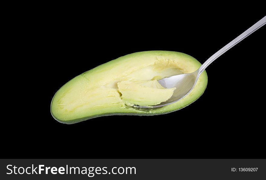 Spoon in the avocado on a black. Spoon in the avocado on a black.