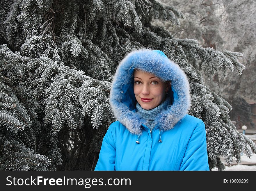 The red-haired girl against the frozen fur-tree branches. The red-haired girl against the frozen fur-tree branches