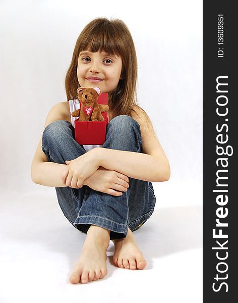 Sitting girl with the toy on knees