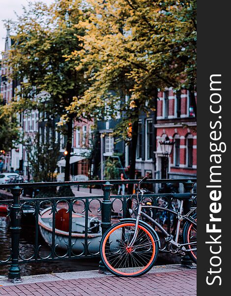 Bike parked on a bridge in Amsterdam, Netherlands. Typical cityscape