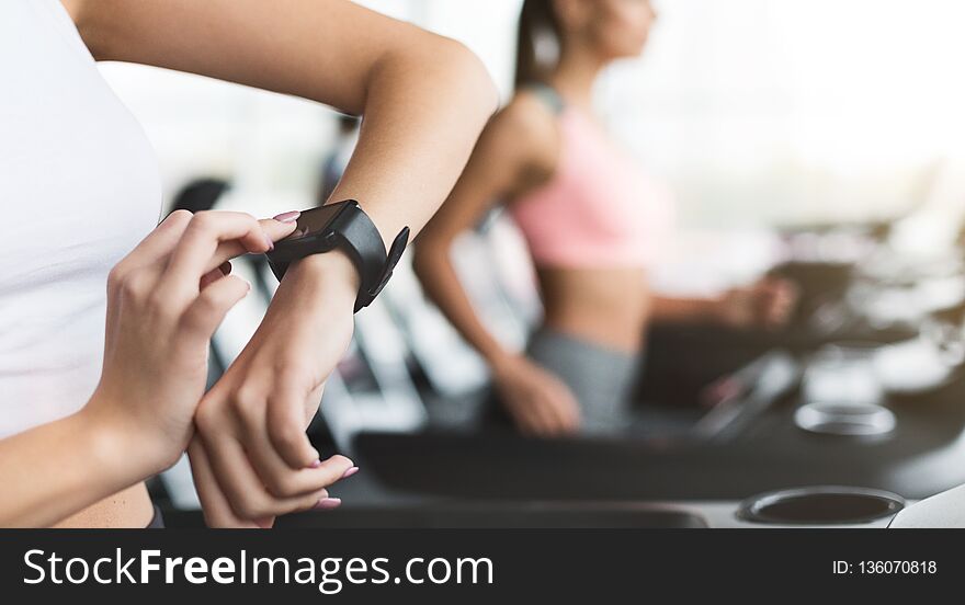 Sportswoman looking at smartwatch with blank screen at gym, crop, copy space