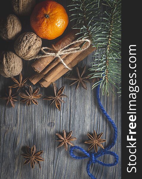 Star anise, bunch of cinnamon, blue thread and orange and next to pine branch, sitting on rustic wooden table surface background. Christmas decor, cosiness, warmth, mulled wine recipe concept. Star anise, bunch of cinnamon, blue thread and orange and next to pine branch, sitting on rustic wooden table surface background. Christmas decor, cosiness, warmth, mulled wine recipe concept